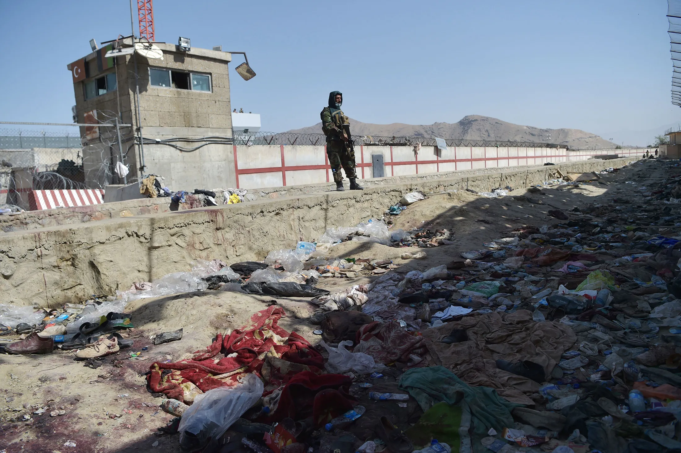 A Taliban fighter stands guard at the site of a&nbsp;suicide bombing at Kabul airport on Aug.&nbsp;27.