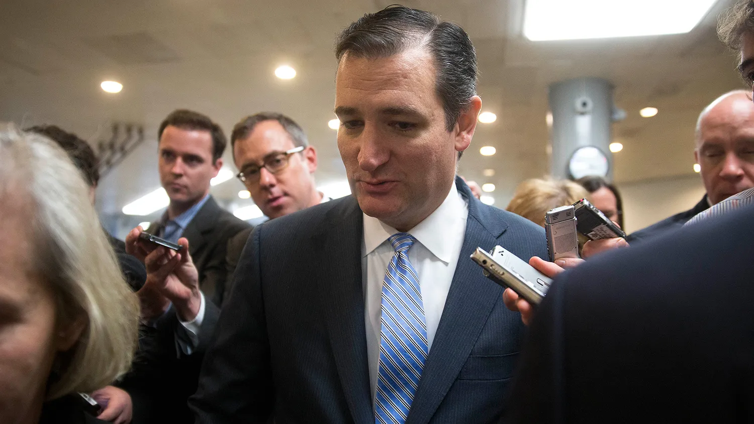 Senator Ted Cruz, a Republican from Texas, talks to members of the media while walking through the U.S. Capitol basement in Washington, D.C., U.S., on Friday, Dec. 12, 2014.
