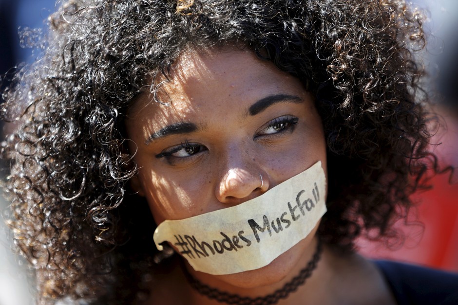 A student wears a sticker calling for the removal of a statue of Cecil John Rhodes from the campus of the University of Cape Town. 