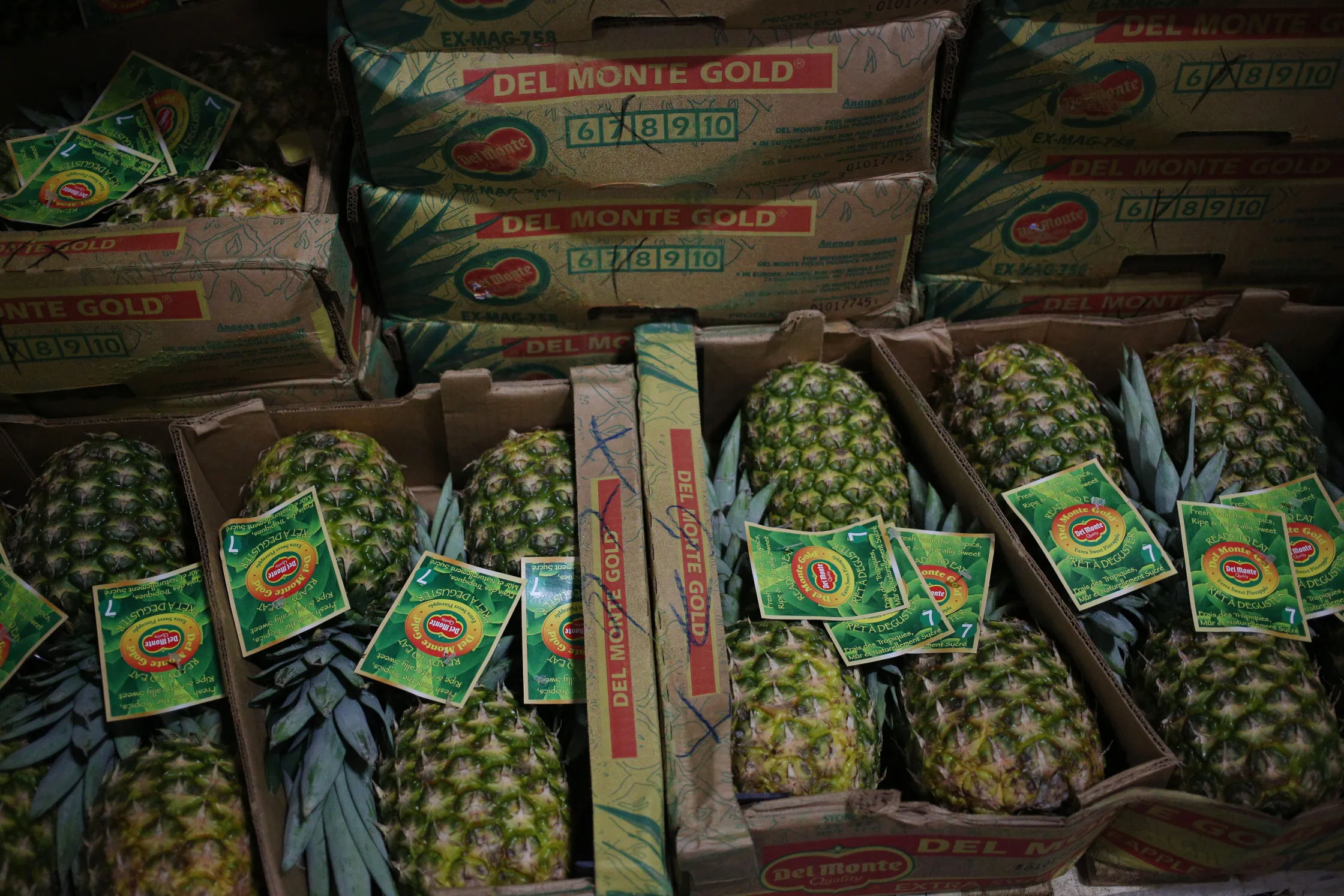 Cases of Dole Food pineapples sit stacked inside cold storage.