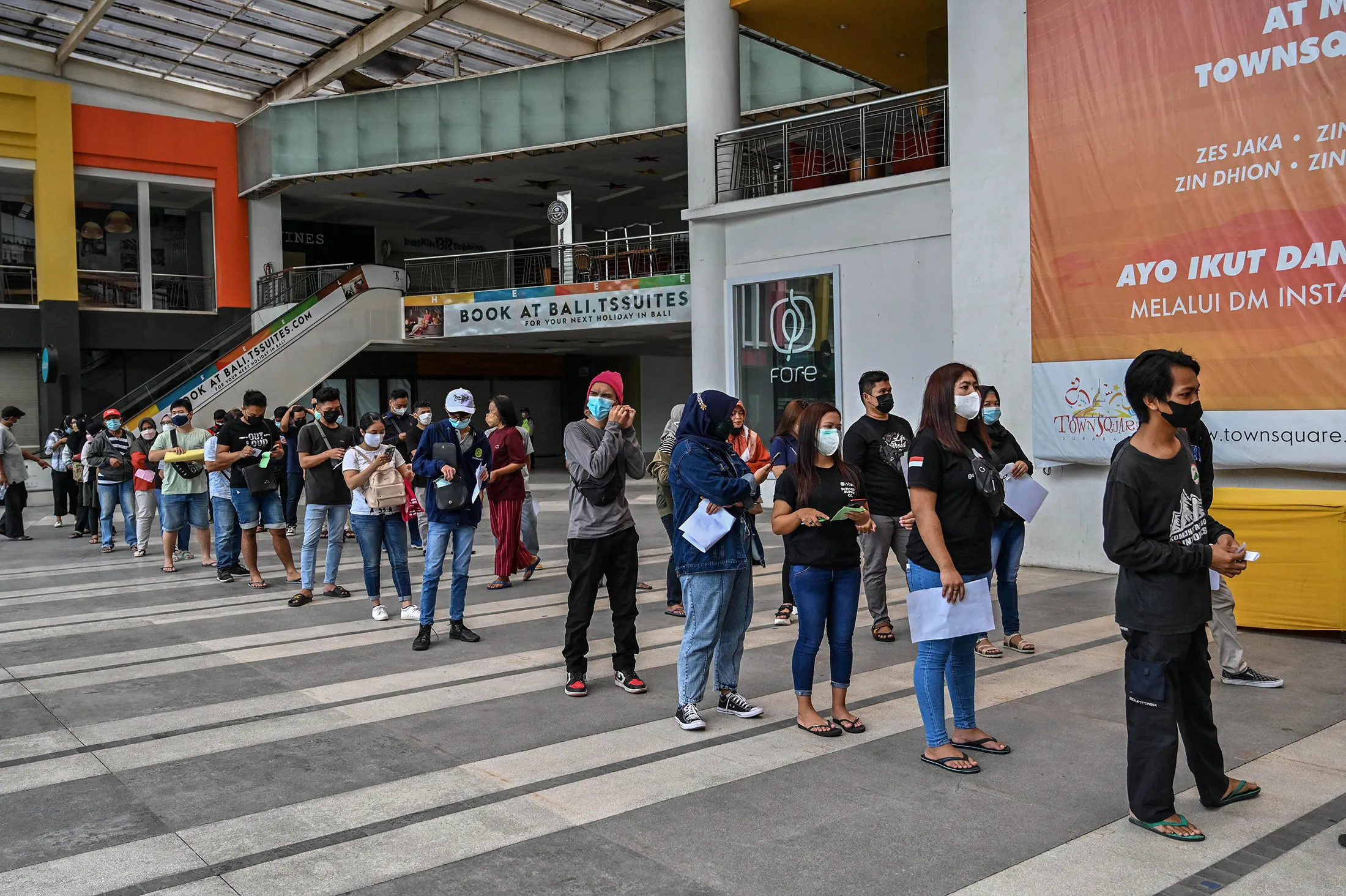 Members of the public stand in line to receive a dose of the Sinovac Covid-19 coronavirus vaccine at a mall in Surabaya on Sept. 23.