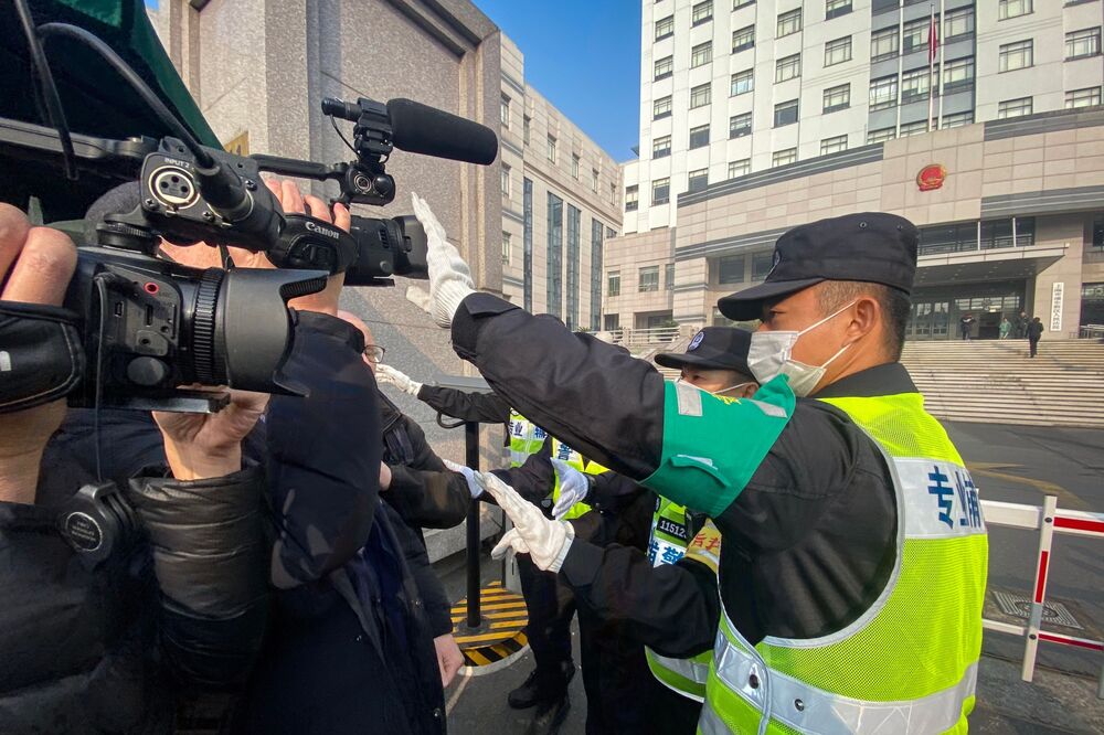 A policeman tries stop journalists from recording outside the Shanghai Pudong New District People's Court, where Chinese citizen journalist Zhang Zhan is set for trial on Dec. 28.