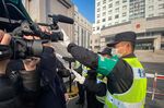 A policeman tries stop journalists from recording outside the Shanghai Pudong New District People's Court, where Chinese citizen journalist Zhang Zhan is set for trial on Dec. 28.