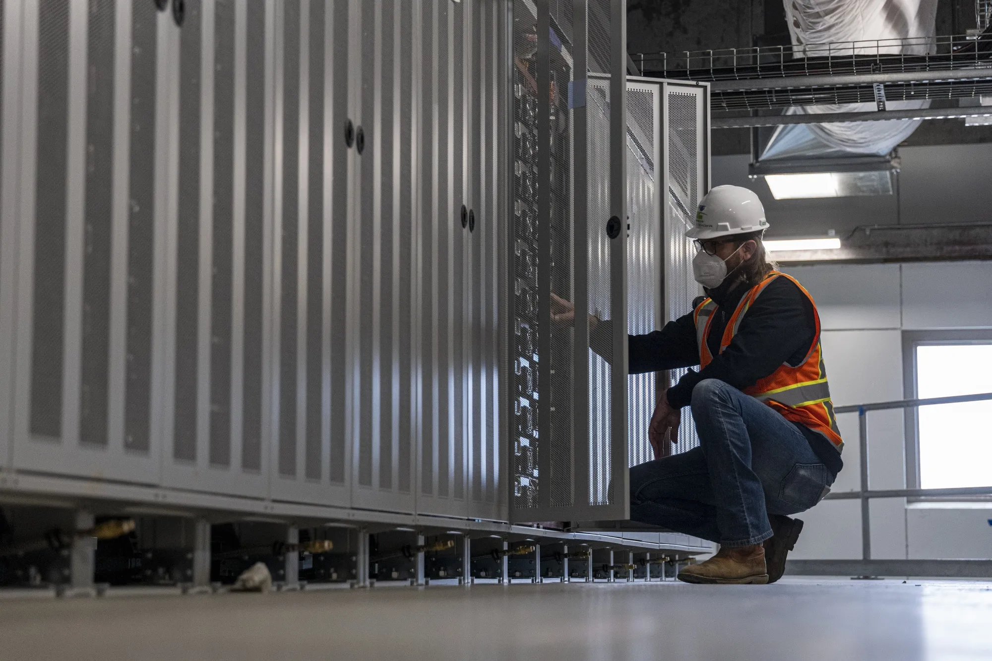 A worker inspects a set of lithium battery modules inside the battery building at the Vistra Corp. Moss Landing Energy Storage Facility in Moss Landing, California, U.S