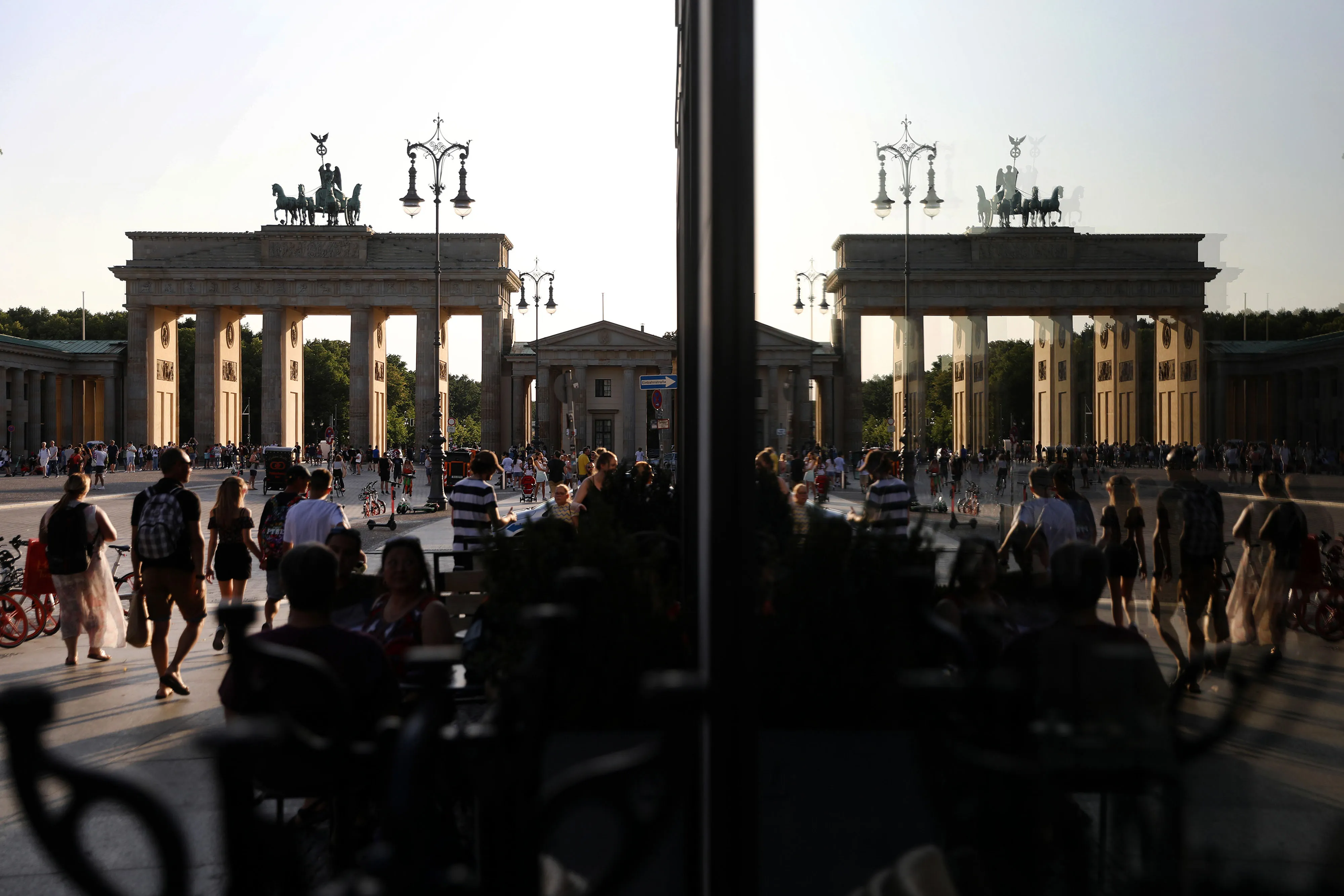Customers sit on a cafe terrace near the Brandenburg Gate in Berlin.