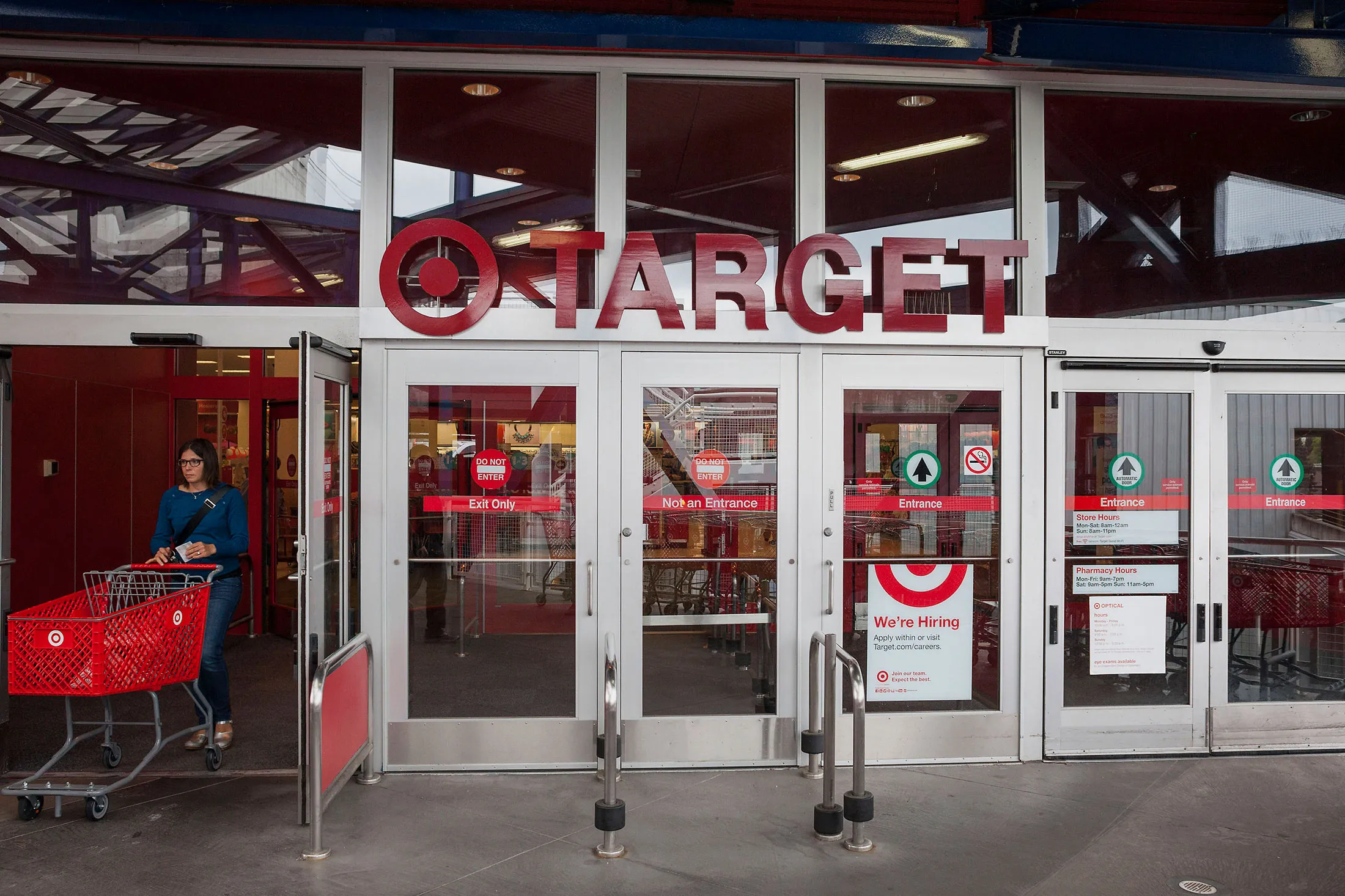 A customer pushes a shopping cart while exiting a Target Corp. store in Seattle, on May 14, 2015.
