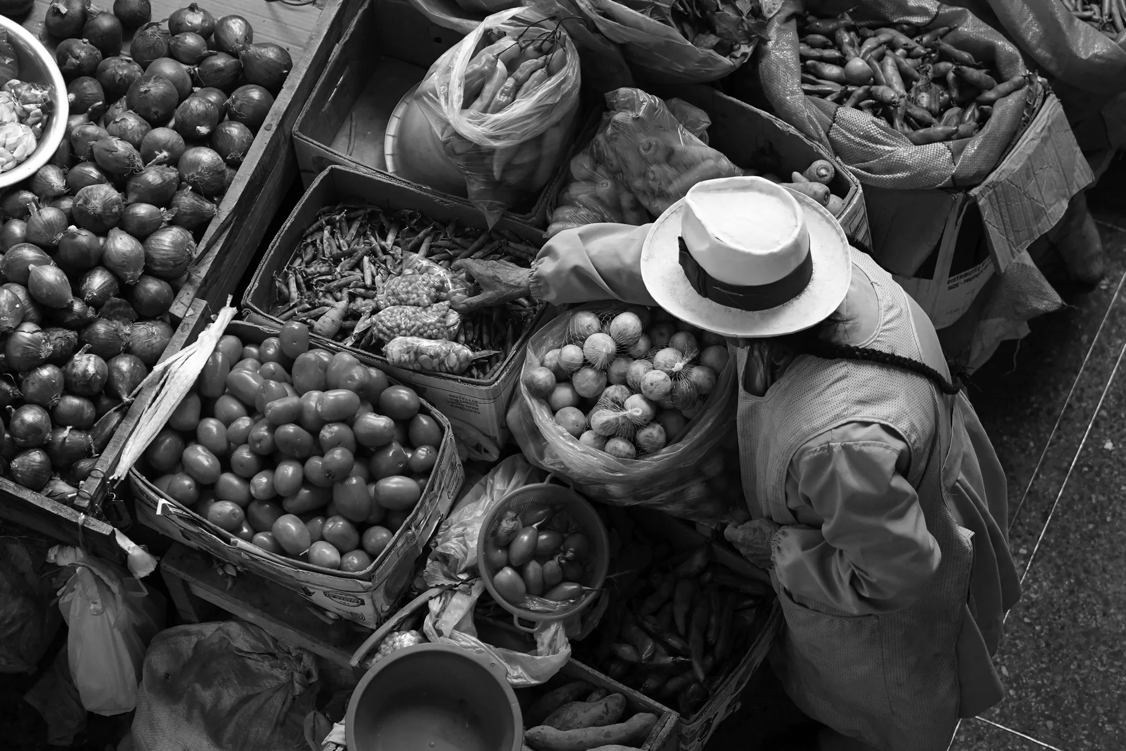 Mercado Modelo de San Sebastián in Cusco selecting produce from the from several bins.
