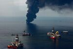 Smoke rises from controlled oil burns of oil on the surface of the water as the Development Driller II, left, and Discoverer Enterprise work at the site of the Deepwater Horizon oil spill in the Gulf of Mexico off the coast of Louisiana, on June 19, 2010.