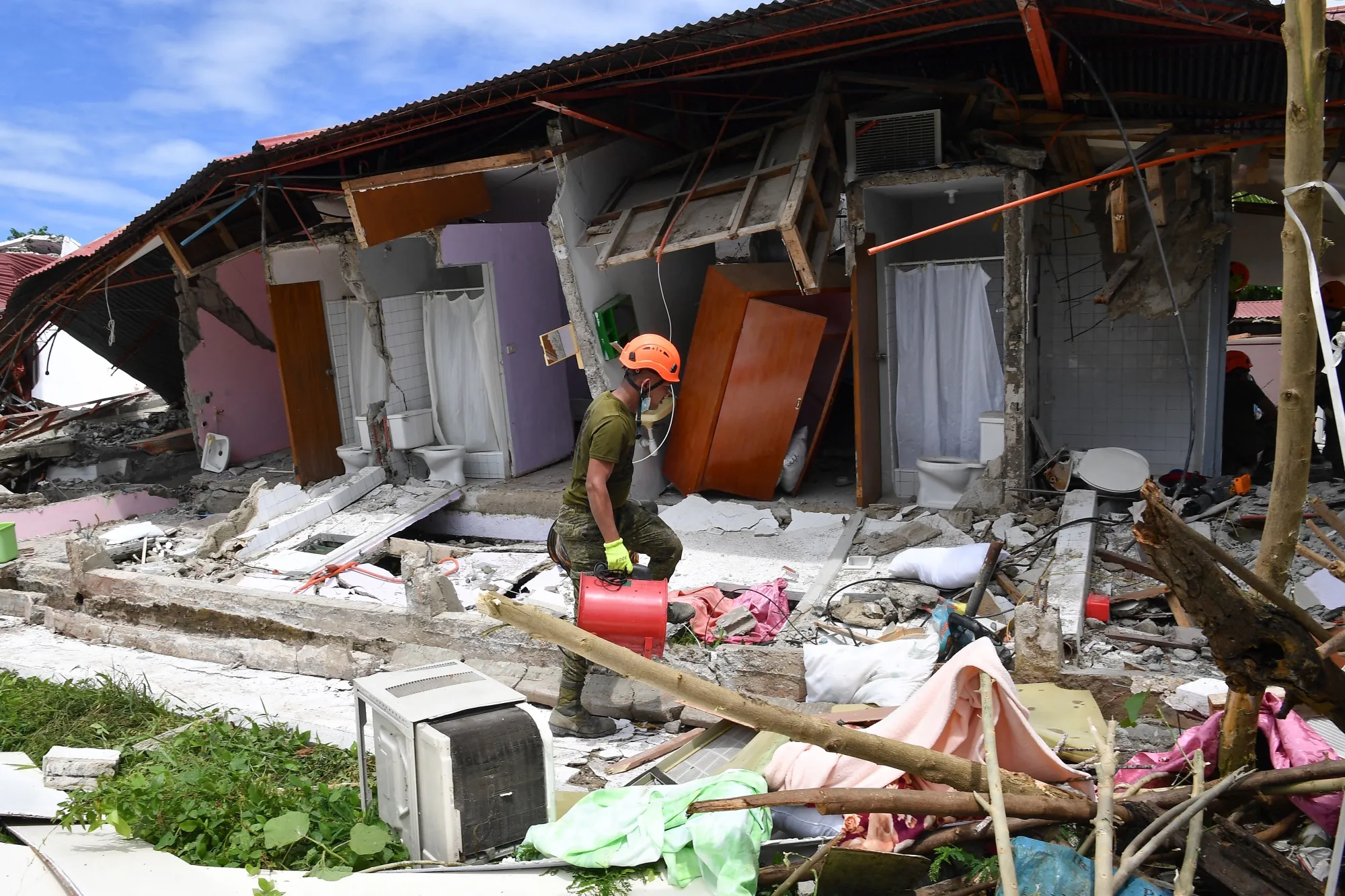 A rescuer at the site of a collapsed building in Bogo City on Oct. 1.