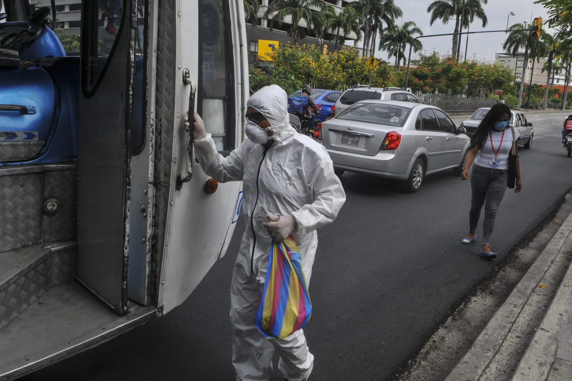 A person wearing personal protective equipment gets on a bus in Guayaquil, Ecuador, on May 15.