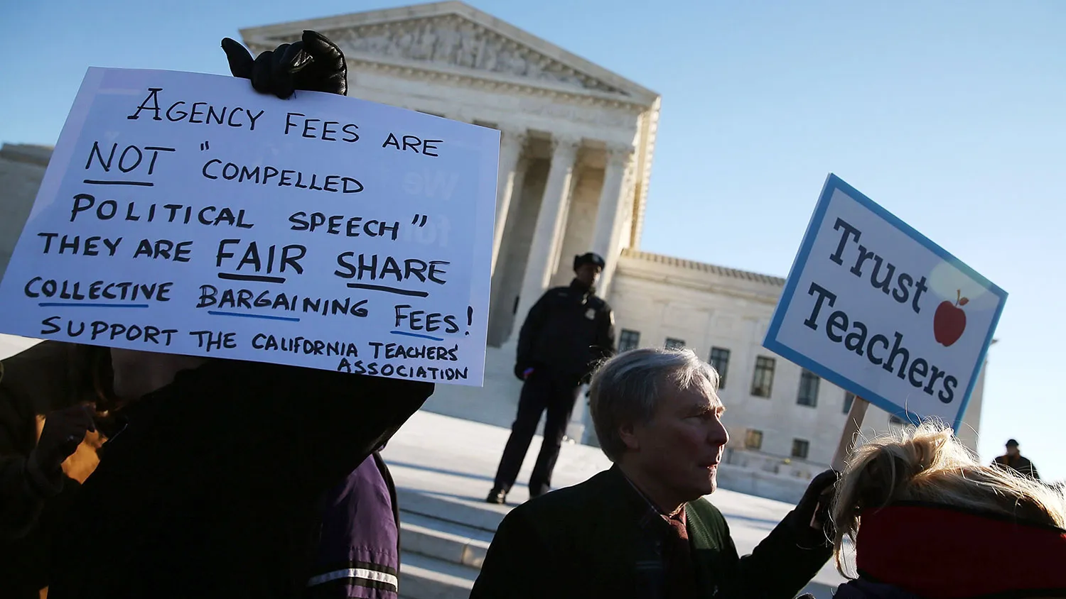 People hold up signs in front of the Supreme Court building on Jan. 11, 2016, in Washington.
