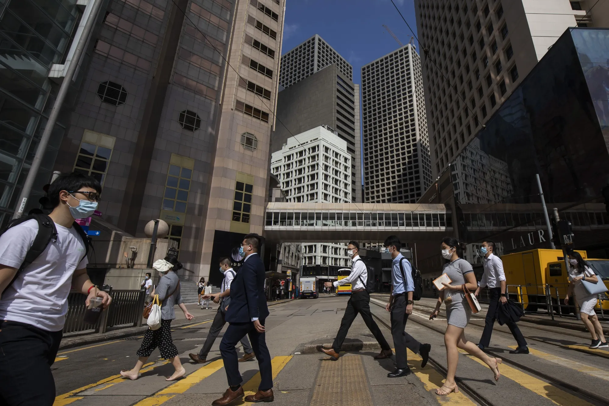 Morning commuters cross a road in Central district in Hong Kong.