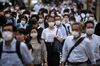 People wearing face masks walk across a road at Shinjuku district of Tokyo on July 21, 2020. (Photo by Philip FONG / AFP) (Photo by PHILIP FONG/AFP via Getty Images)