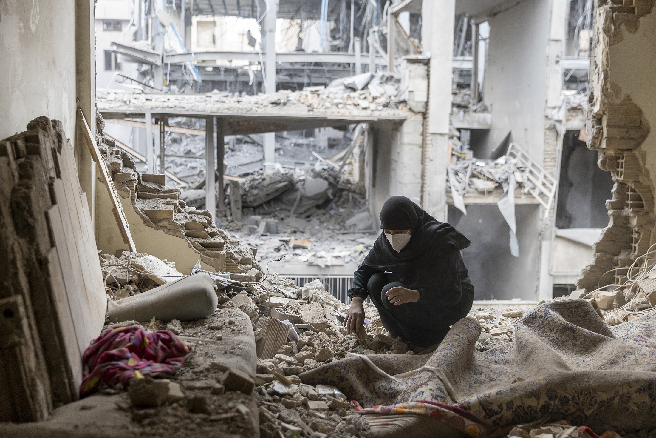 A woman sifts through the rubble of her home following strikes in the Beryanak district of Tehran, on March 15.