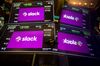 Monitor displays Slack Technologies Inc. signage during the company's initial public offering (IPO) on the floor of the New York Stock Exchange (NYSE) in New York, U.S., on Thursday, June 20, 2019. Following in the footsteps of music-streaming service Spotify Technology SA last year, the workplace messaging application is set to start trading on the New York Stock Exchange Thursday via a direct listing.