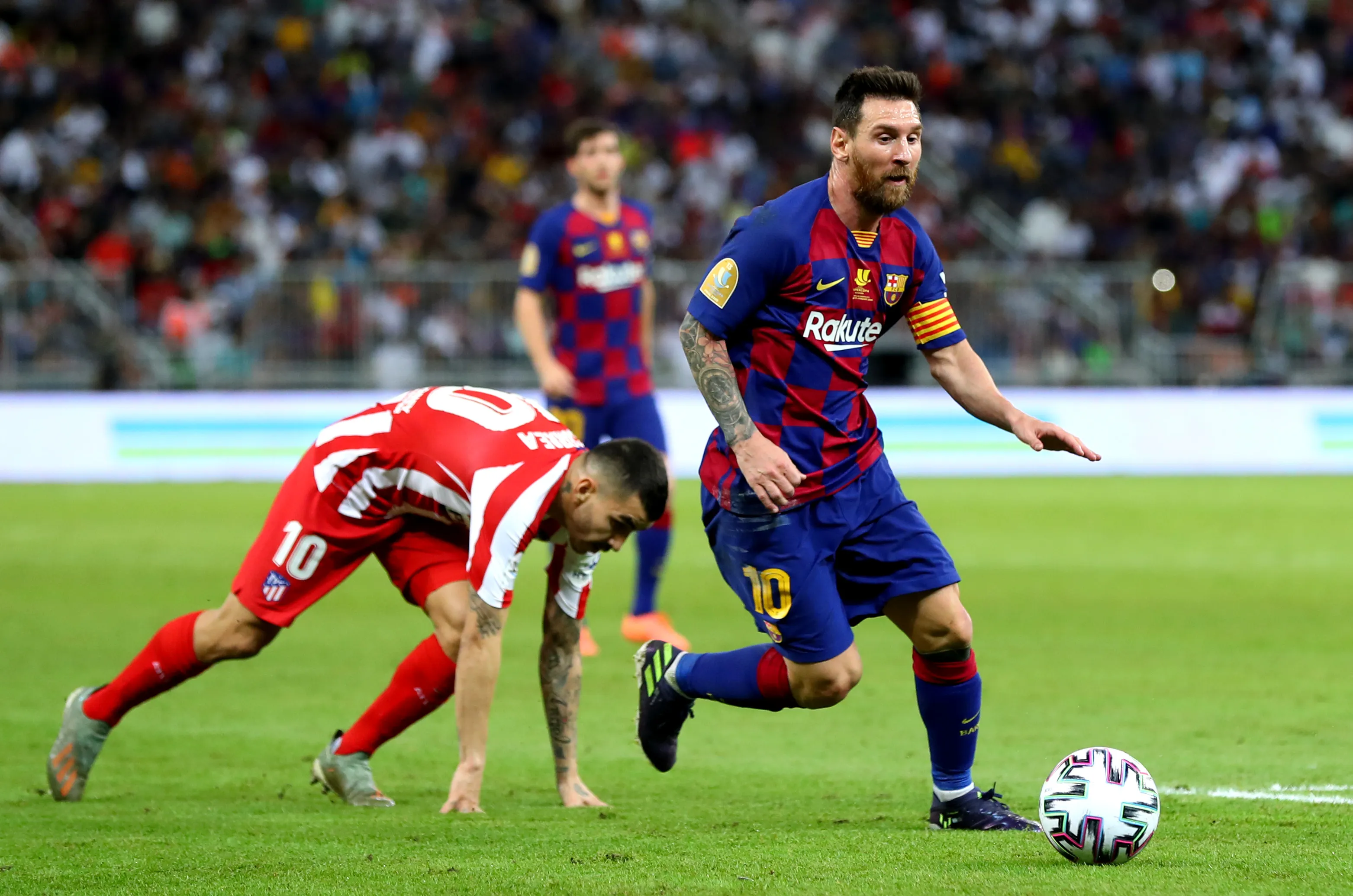 Lionel Messi of Barcelona avoids Angel Correa of Atletico Madrid during the Supercopa de Espana semifinal at King Abdullah Sports City on January 9, 2020 in Jeddah, Saudi Arabia. (Photo by Francois Nel/Getty Images)