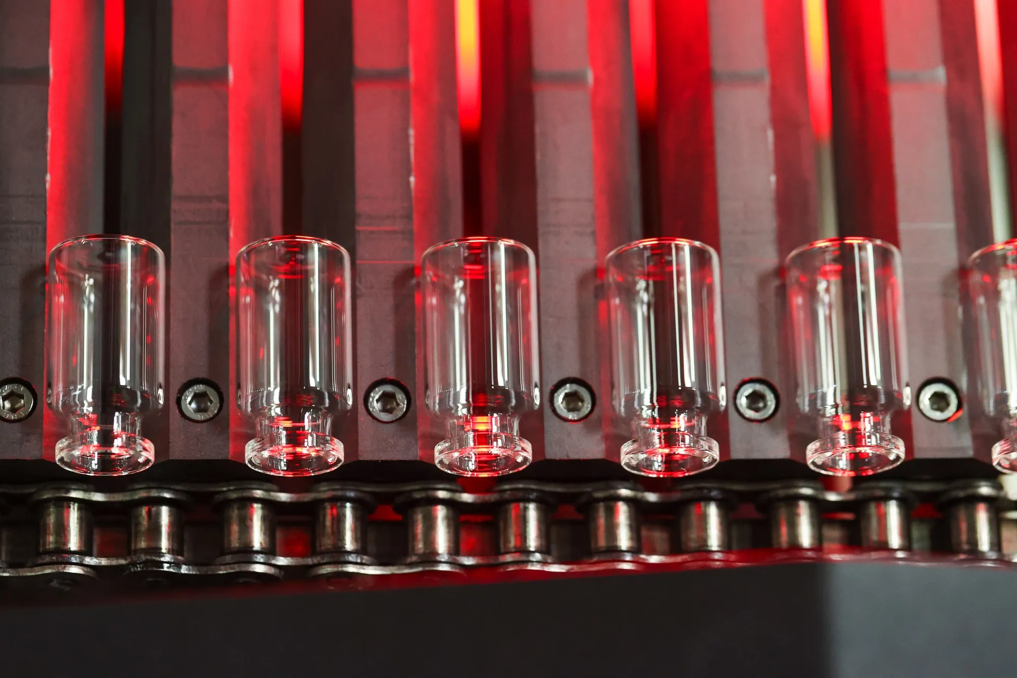 Glass vials move along a conveyor at the Gerresheimer medical glassware factory 