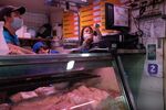 A butcher checks a transaction at a market in Caracas, Venezuela,