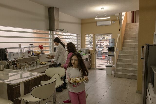 Yanina Court and her husband and daughter Luna prepare desert and coffee inside the kitchen of their home. 