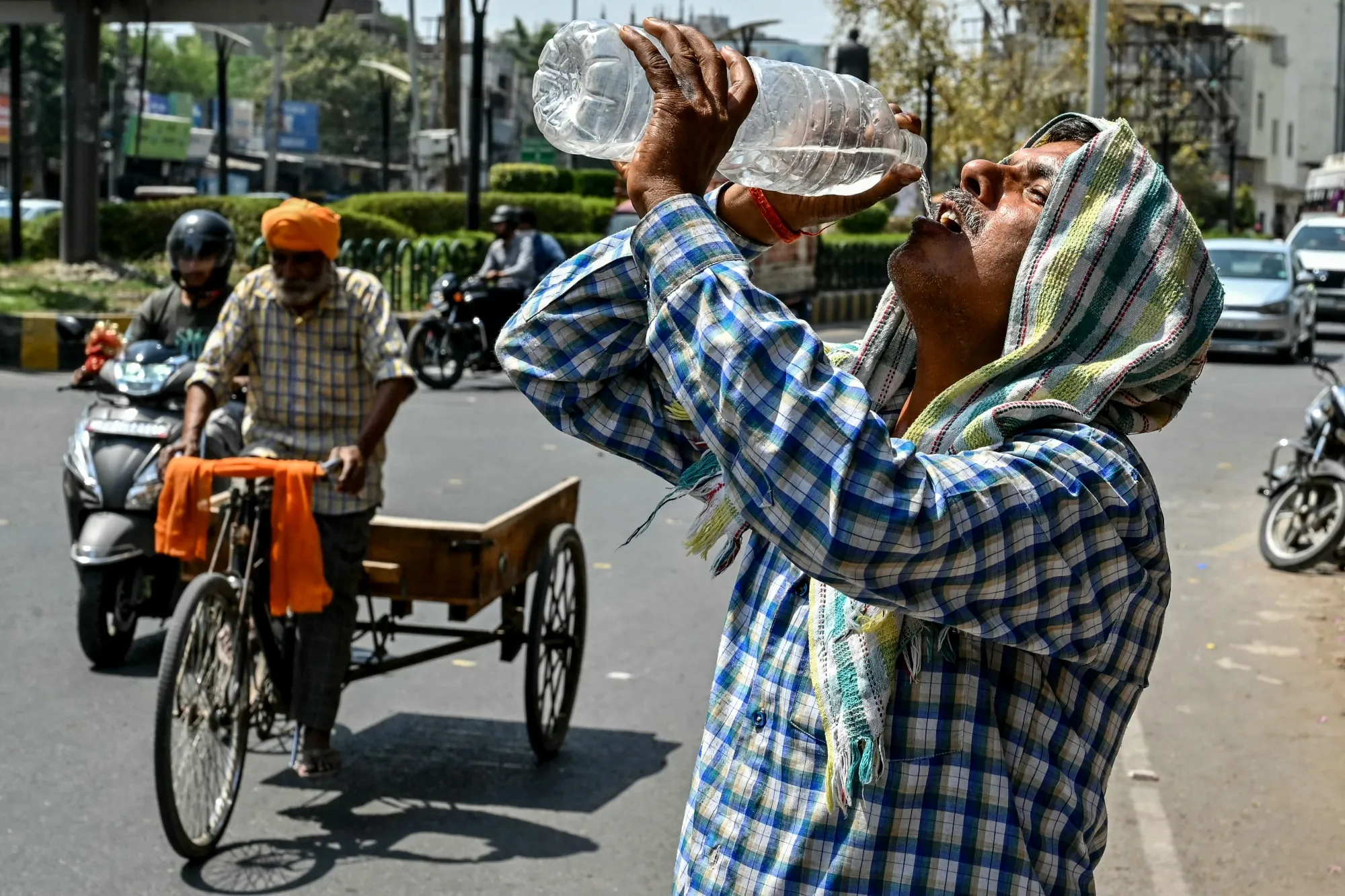 A man drinks water along a road on a hot summer day in Amritsar, India on April 7.