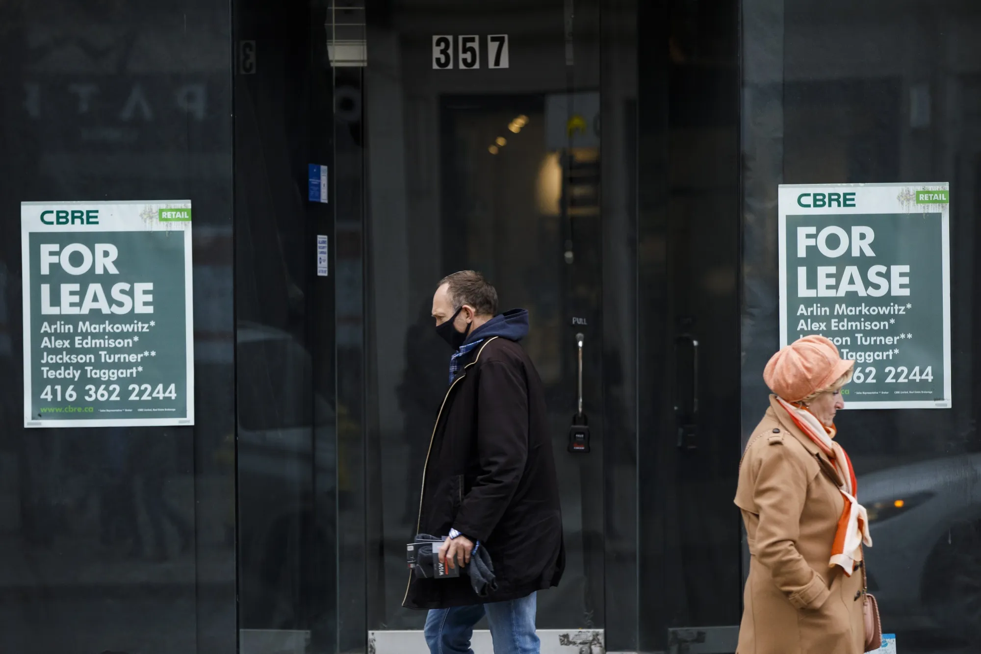 Pedestrians walk past a vacant storefront in Toronto on Nov. 13.