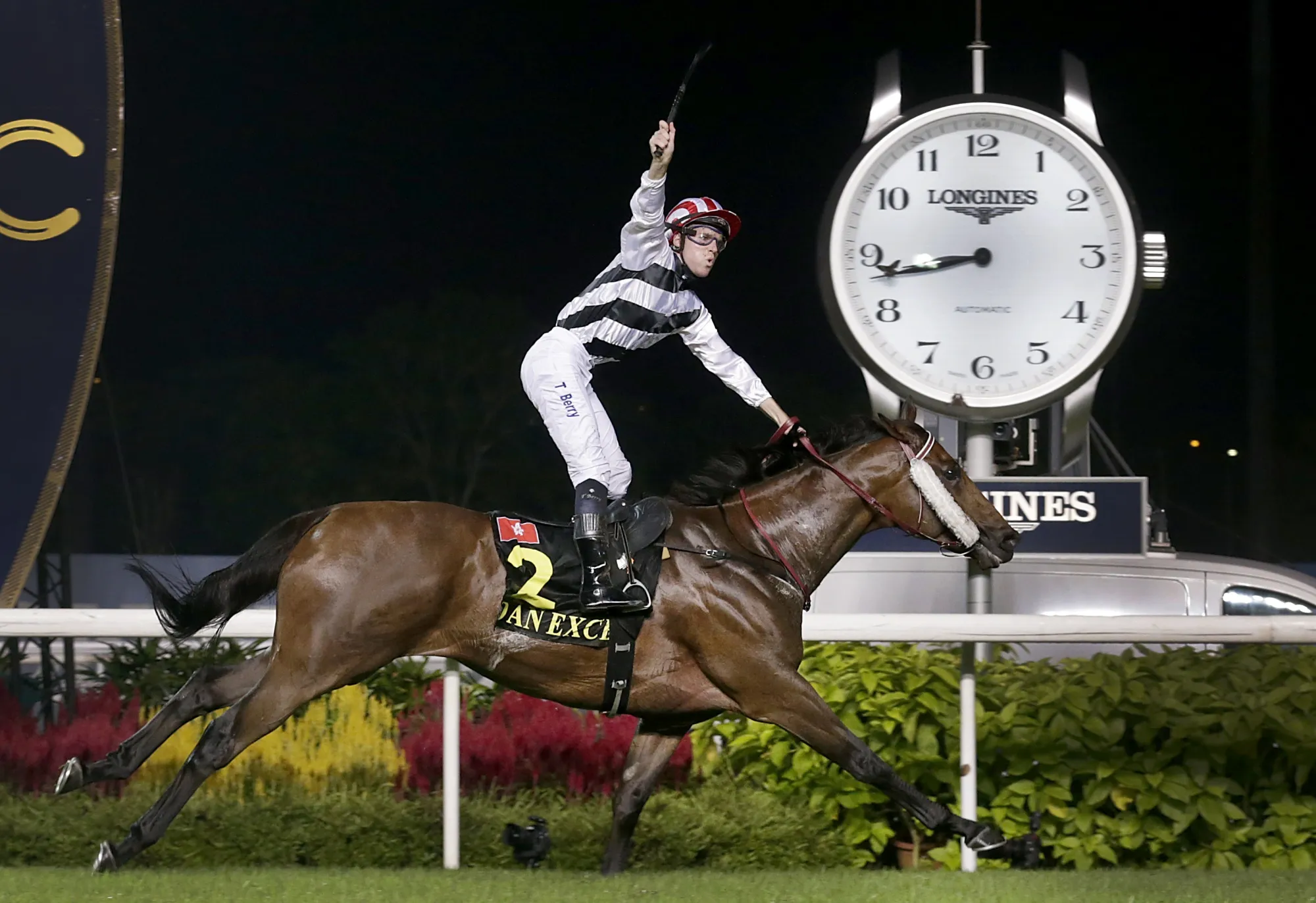 Australian jockey Tommy Berry riding horse Dan Excel celebrates just after he crosses the finish line to win the Singapore Airlines International Cup horse race at the Singapore Turf Club on May 18, 2014.