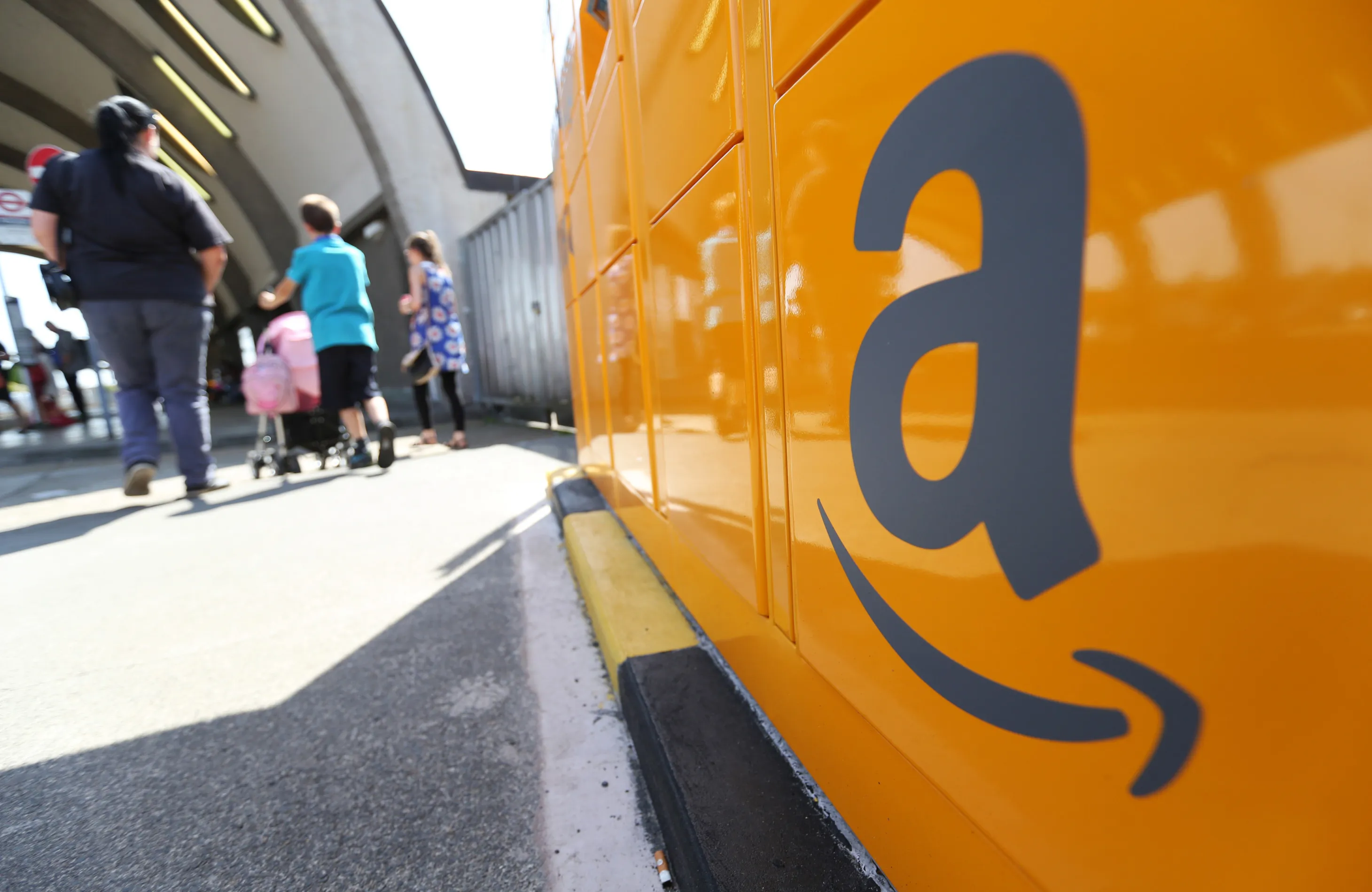 The Amazon logo sits on an Amazon.com Inc. pickup and collect locker at Newbury Park railway station in Newbury Park, U.K., on Wednesday, July 23, 2014. U.K. retail sales rose less than economists forecast in June as clothing volumes fell after stores postponed discounting due to hot weather.