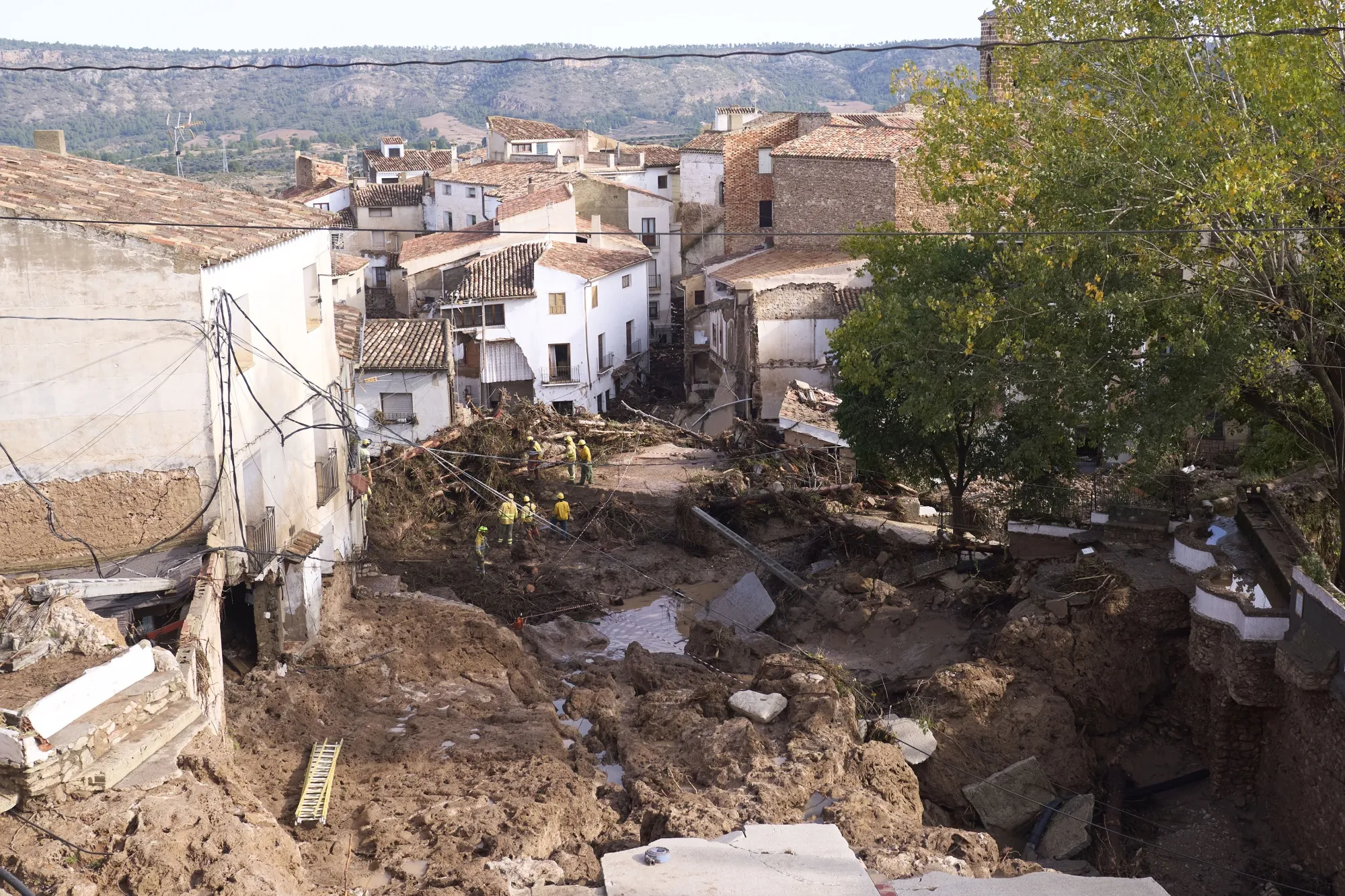 Emergency workers clear debris the morning after heavy rains and flash floods hit the area in Letur on Oct. 30.