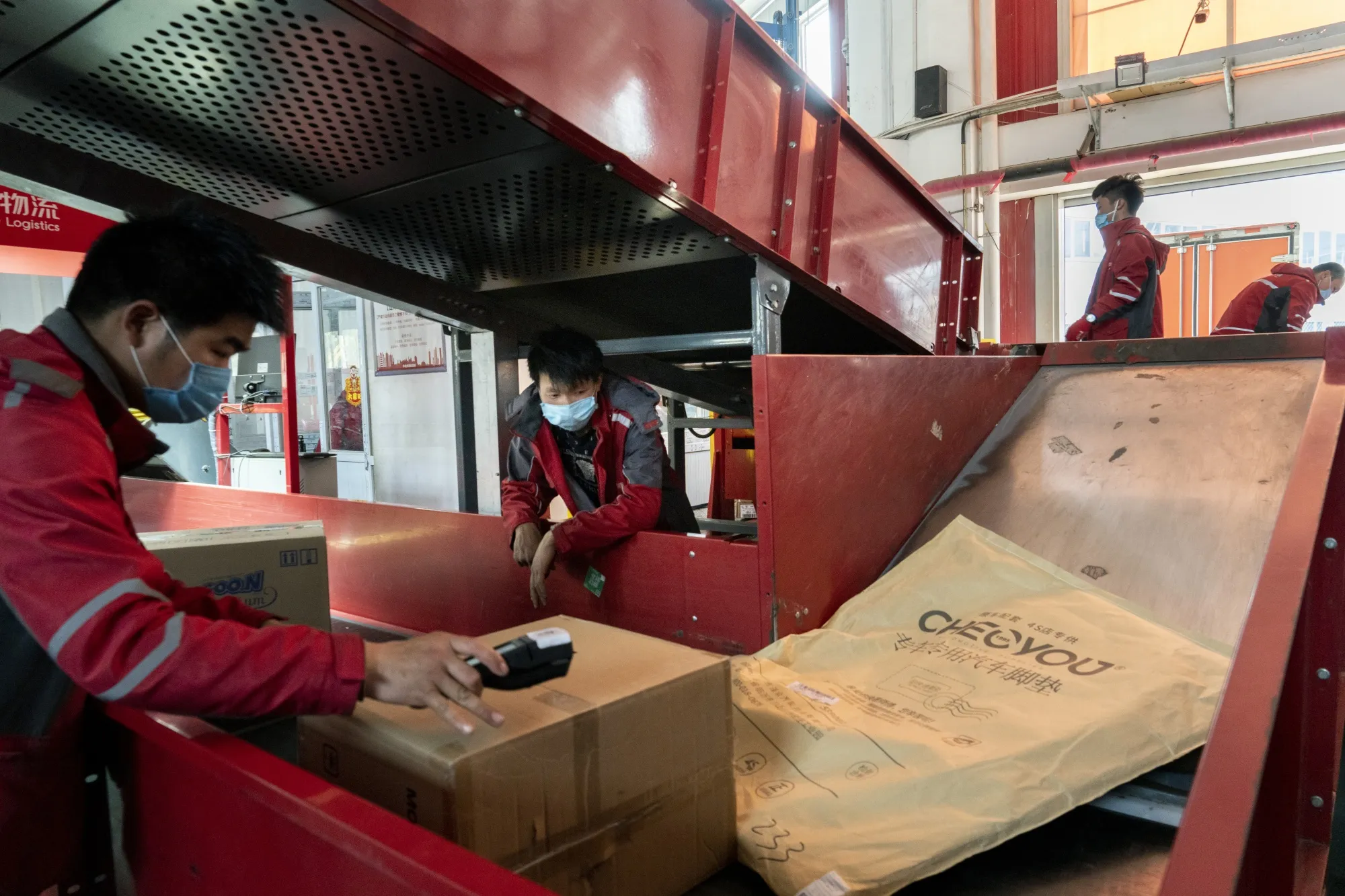 Employees sort parcels at a JD.com Inc. delivery station in Beijing.