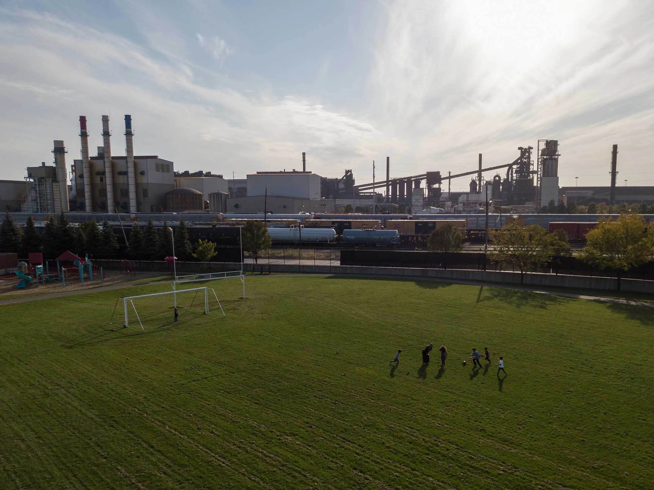 A family plays soccer at Salina Elementary, next to the Dearborn Industrial natural-gas-powered electricity-generating facility.