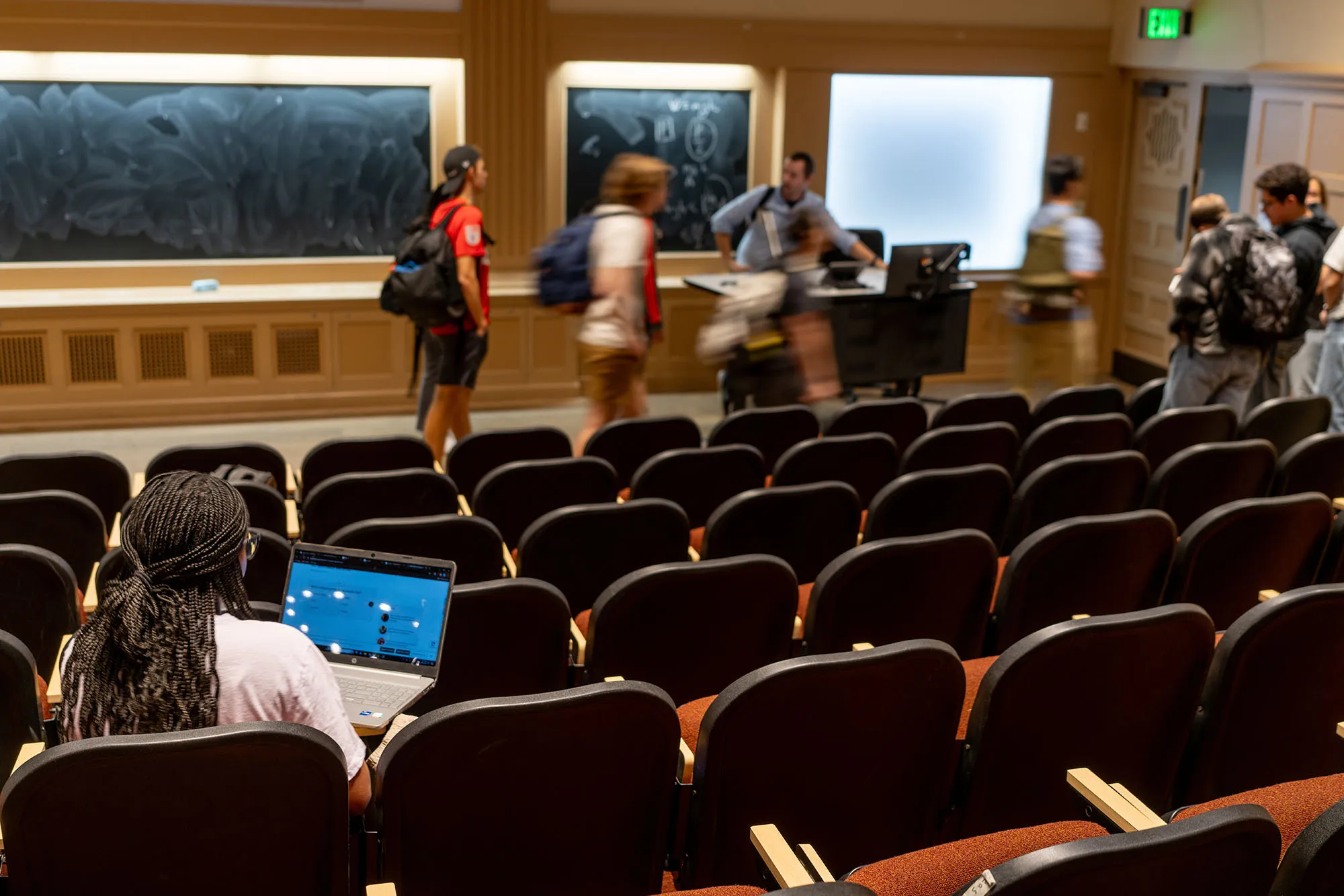 A student sits in a lecture hall while class is dismissed at the University of Texas at Austin.