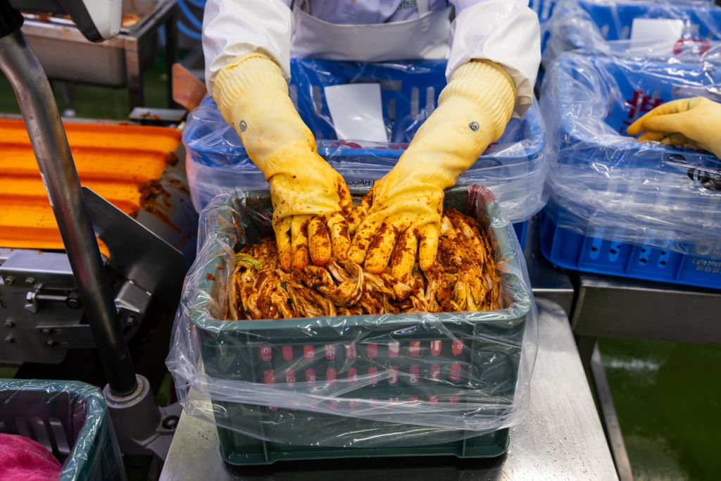 An employee wraps a bag of kimchi.