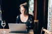 Young Woman Using Laptop In Bar