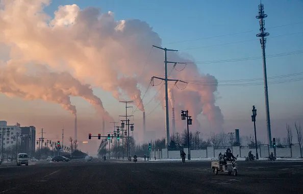 Chinese workers commute as smoke billows from a coal fired power plant&nbsp; in Shanxi, China.&nbsp;
