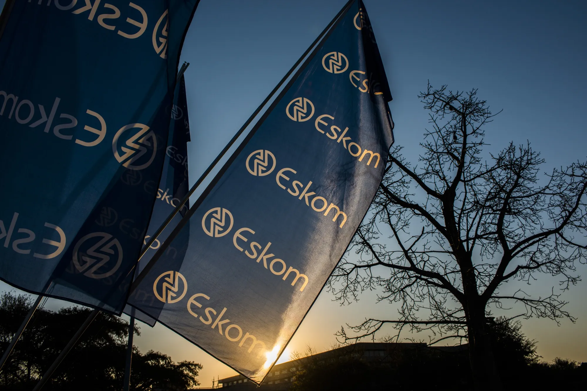 Company flags fly outside the Eskom Holdings SOC Ltd. Megawatt Park headquarters office in Johannesburg.