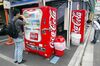 Tokyo residents purchase soft drinks from a Coca-Cola vending machine in Tokyo .