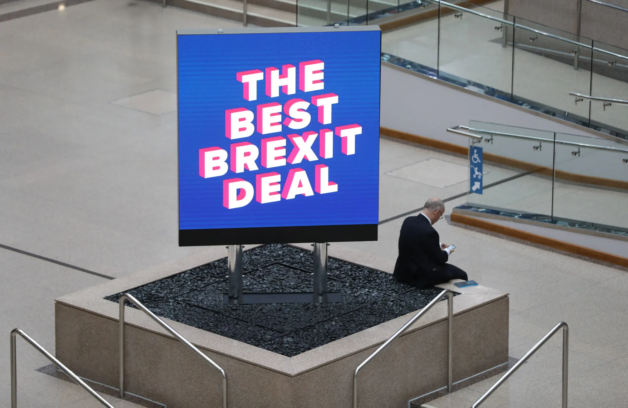 A delegate sits next to a sign reading 'The Best Brexit Deal'' during the Conservative Party annual conference in Birmingham.&nbsp;