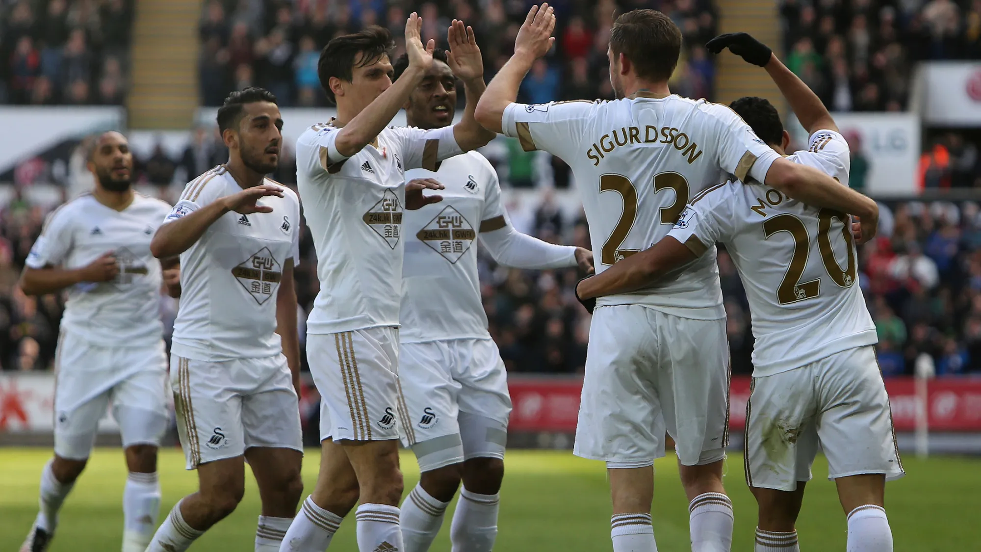 Swansea City's Icelandic midfielder Gylfi Sigurdsson, second right, celebrates scoring with teammates during the English Premier League football match between Swansea City and Chelsea.
