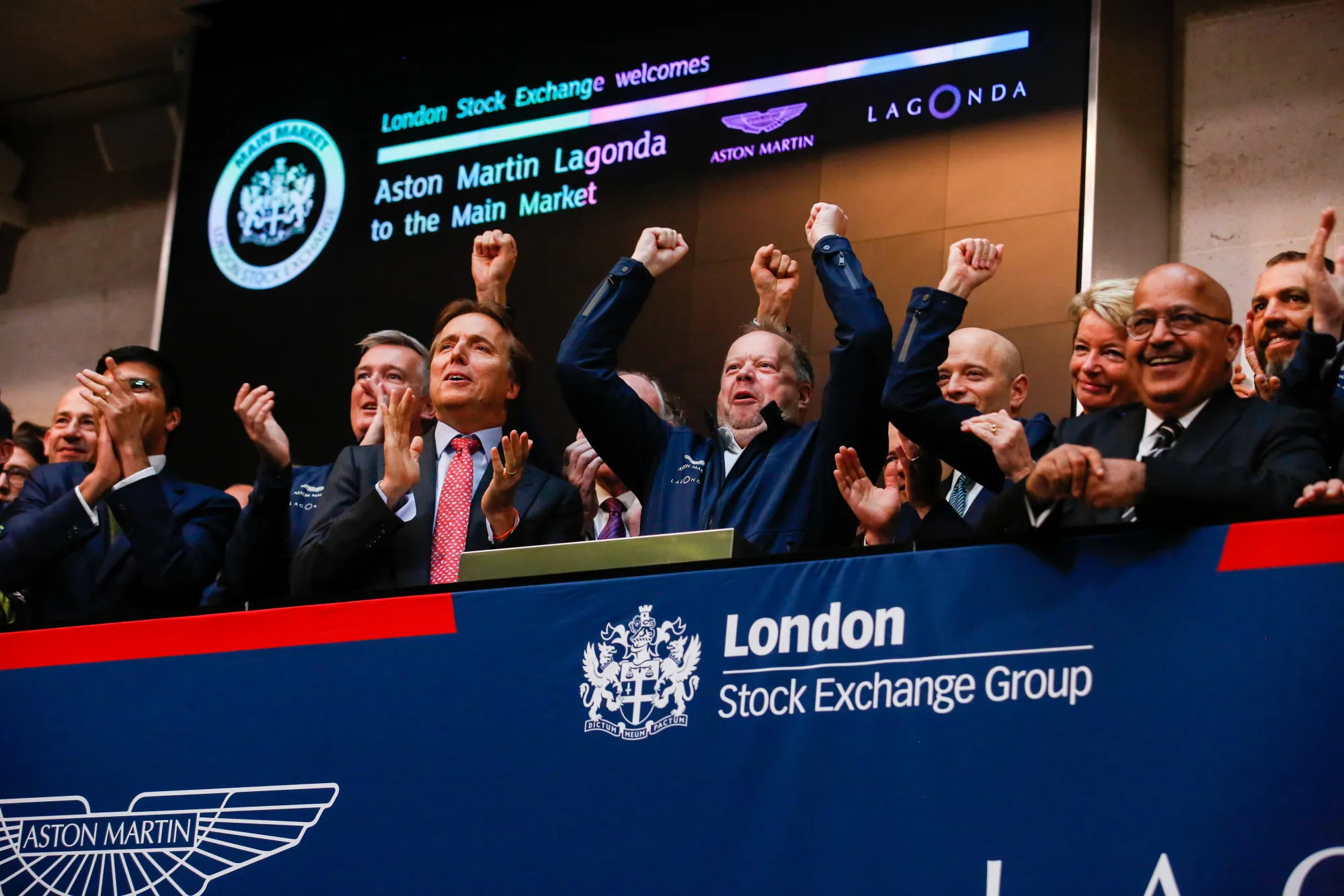 Aston Martin CEO Andy Palmer, center, reacts to the trading debut of the company on the London Stock Exchange, Oct. 3, 2018