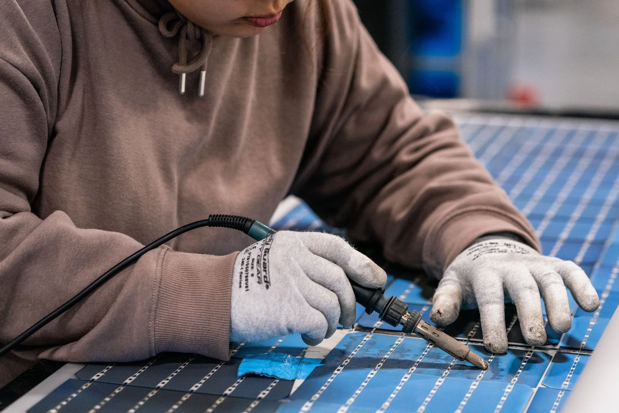 An employee solders solar panel cells at a manufacturing facility in Dalton, Georgia.