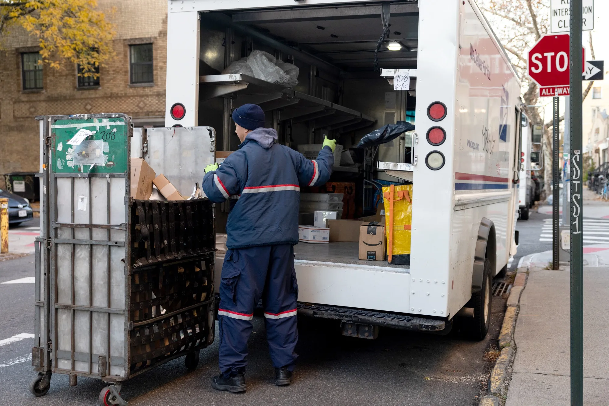 A USPS worker delivers packages in New York.