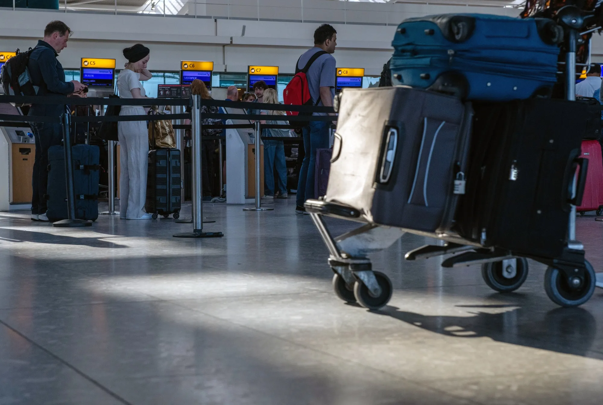 Passengers queue to check in at the departures hall of Terminal 5 at London Heathrow Airport in London, UK.