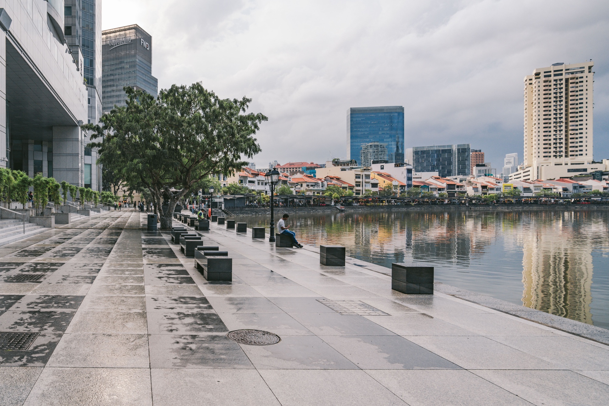 A visitor sits on the empty quayside in Singapore