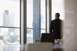 Businessman looking out conference room window