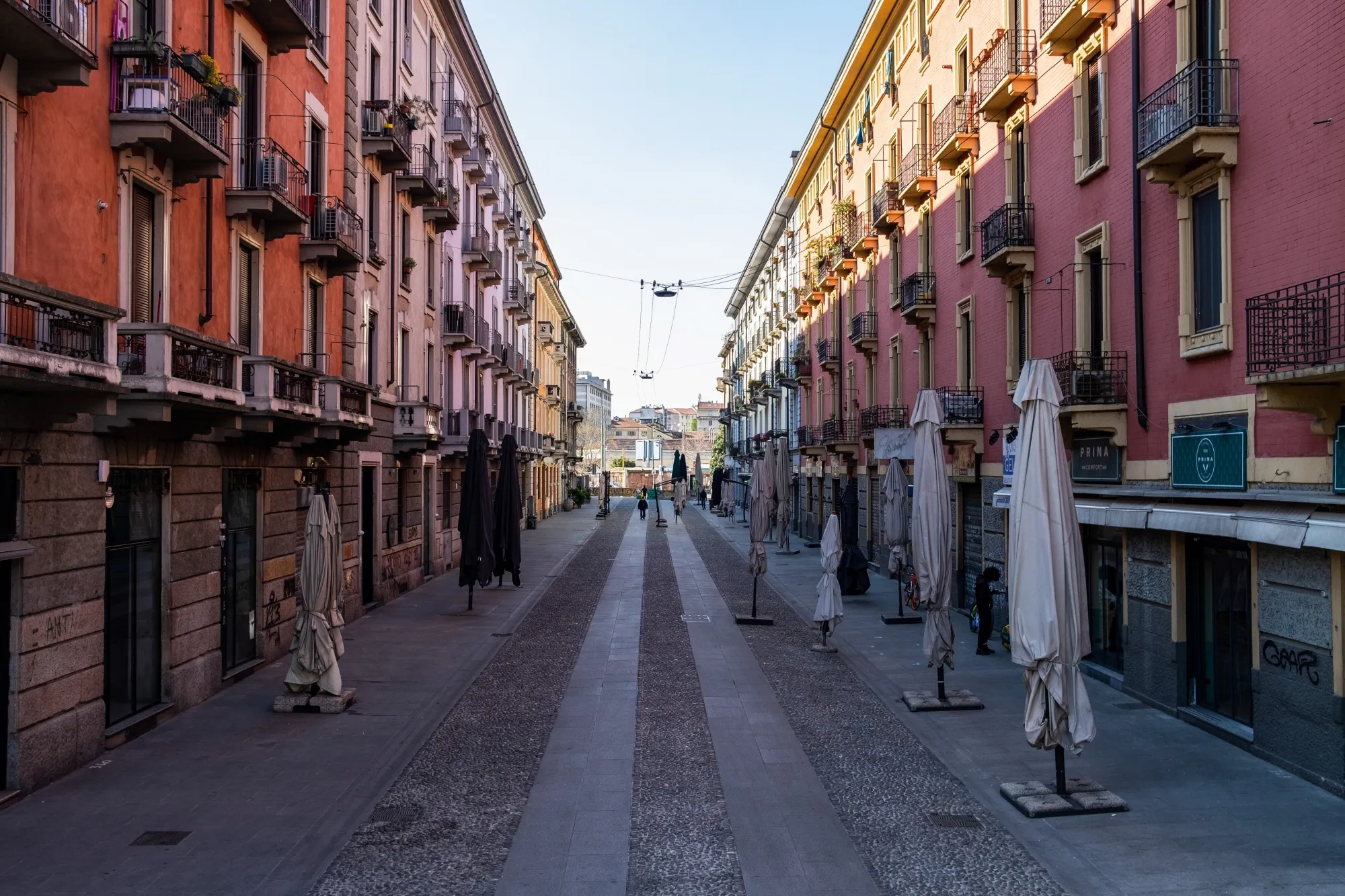 Parasols for closed cafes line a street leading to the Navigli canal system in Milan, Italy April 8.