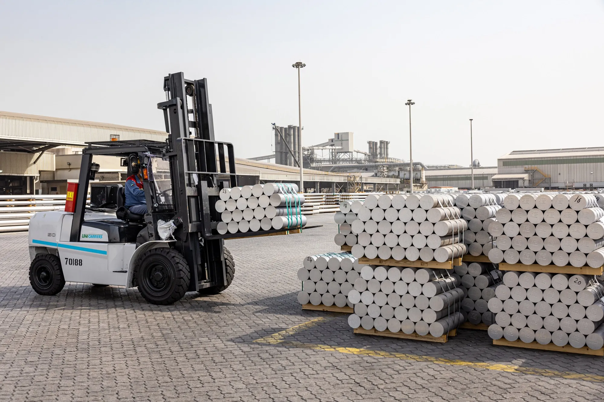 A worker uses a forklift to transport aluminium billets at the Emirates Global Aluminium Al Taweelah plant in Abu Dhabi.