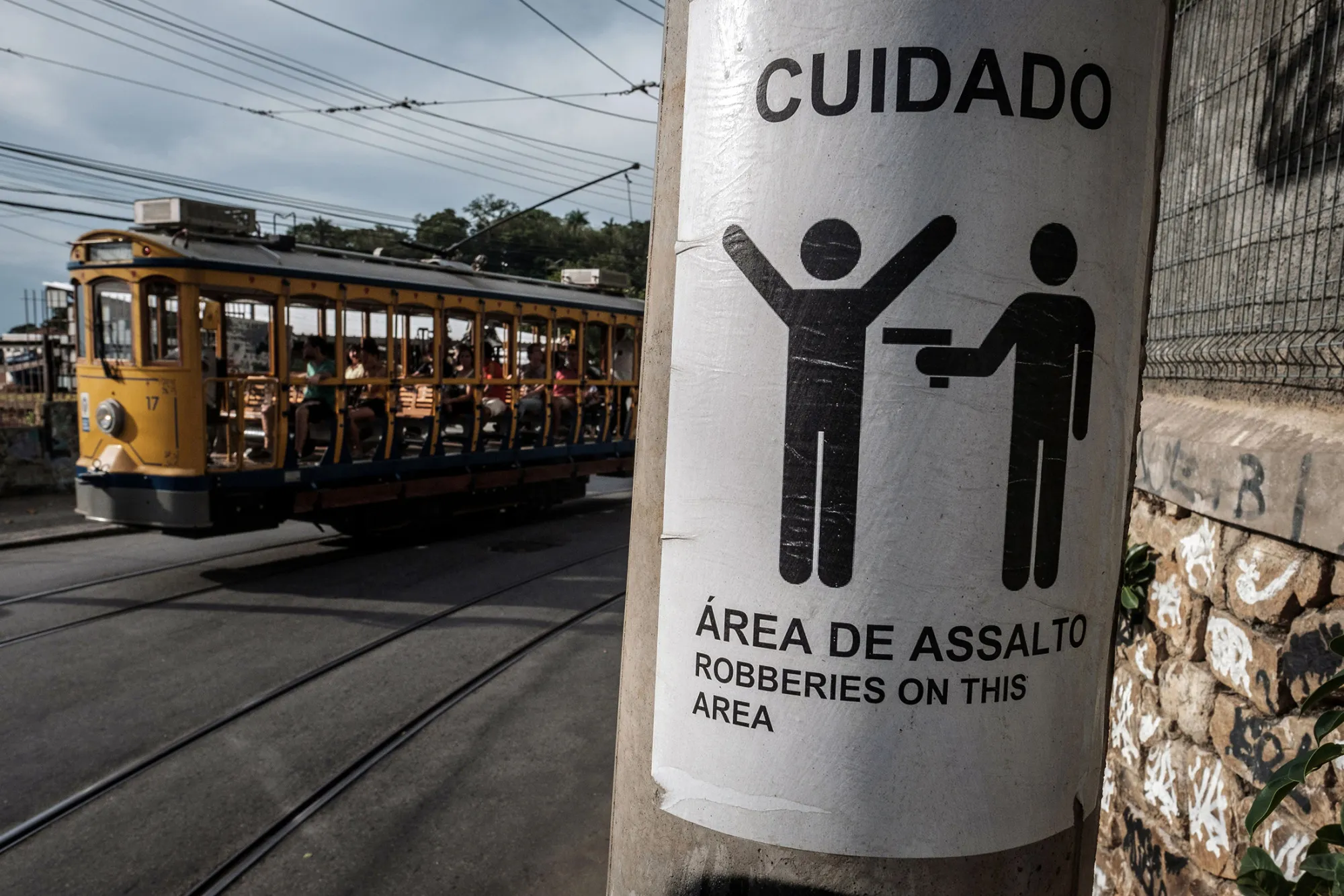 A street car passes by a sign warning against robberies in the Santa Teresa neighborhood of Rio.
