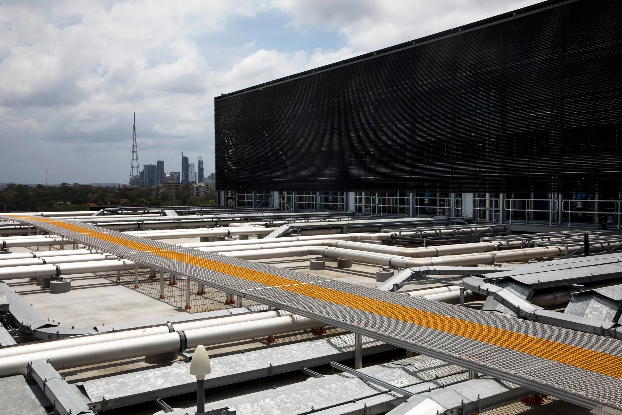 Pipes carry cold water near cooling towers at a NextDC data center in Sydney. CEO Craig Scroggie told a conference in the Sydney on Thursday that it was time to “hit the gas” amid the company’s fundraising tear. 