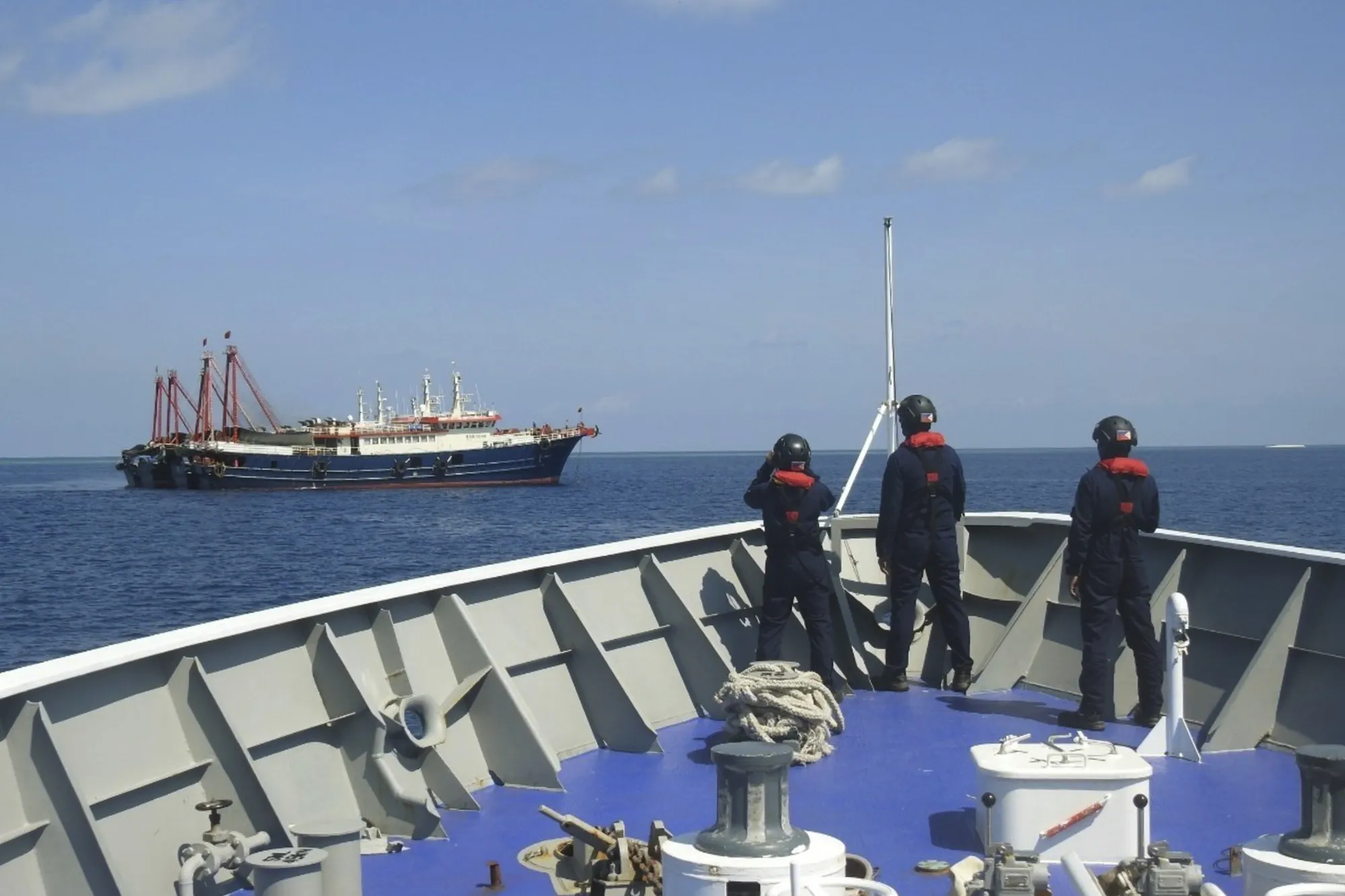 The Philippine Coast Guard personnel patrol beside ships said to be Chinese militia vessels at Sabina Shoal in the South China Sea on April 27.