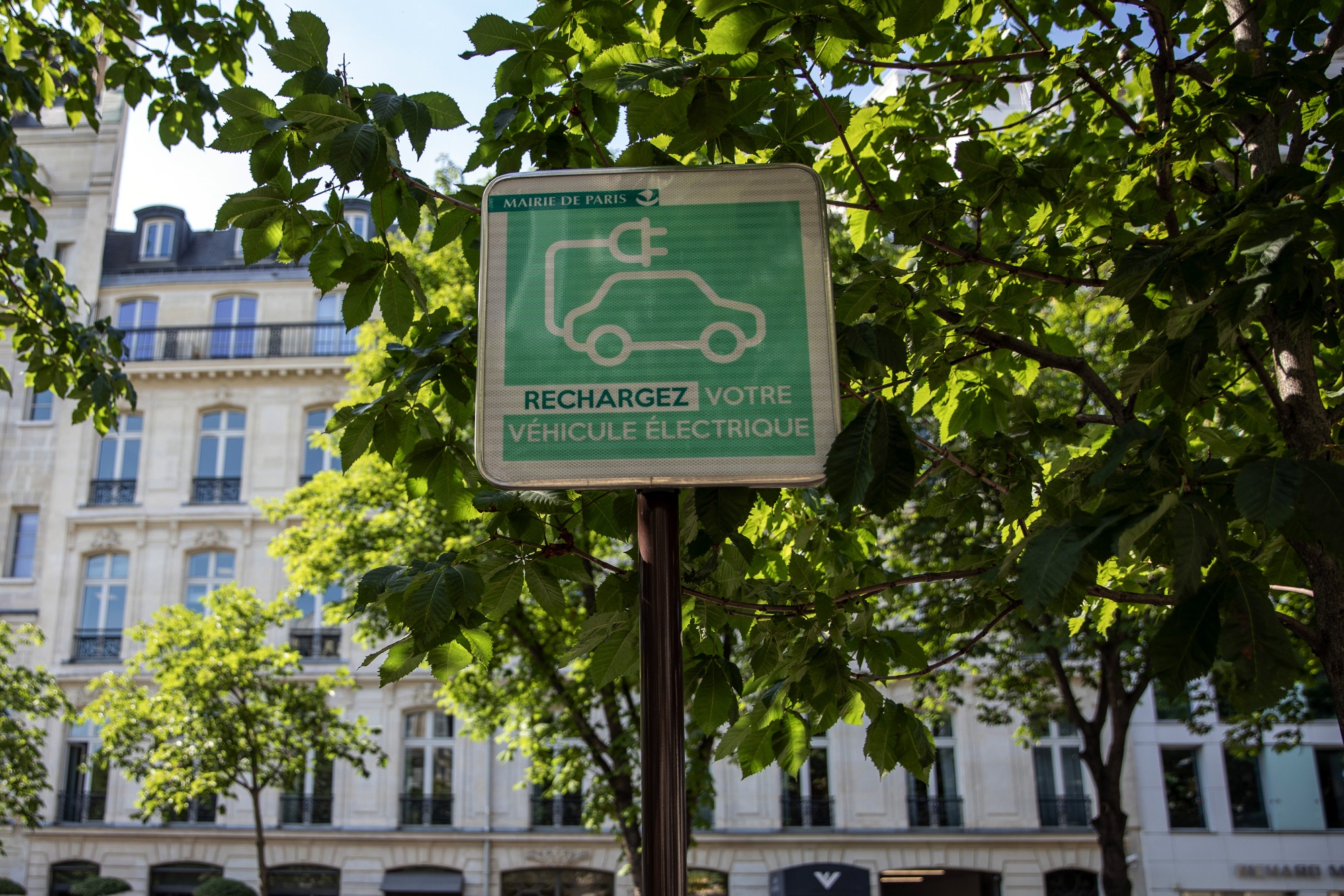 An electric vehicle charging station street sign sits in Paris. The guidelines include&nbsp;investments ranging from high-speed broadband to electric-vehicle charging stations.